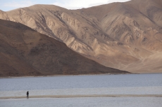 beautiful scenic view of desert mountains and a man standing on river 