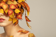 model covered with leaves portraying autumn