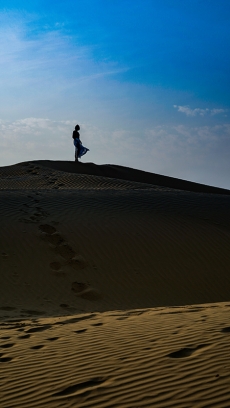 A Person Standing on a Sand Dune
