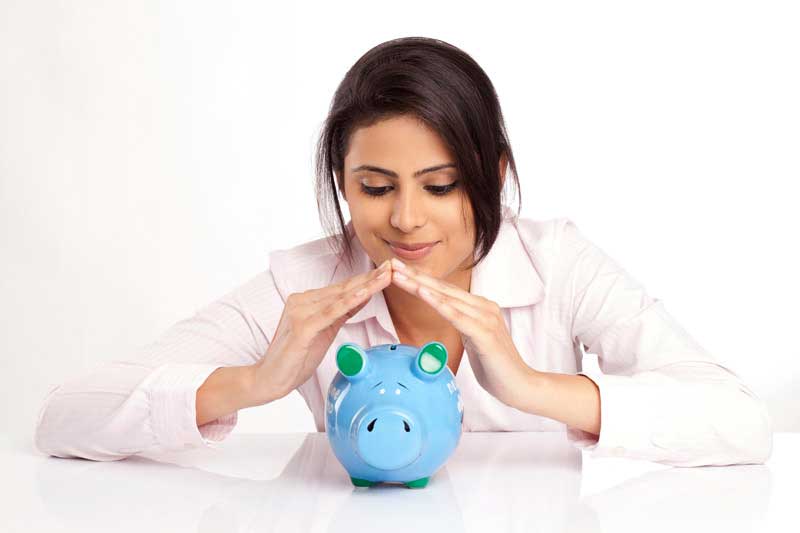 woman in a pink shirt with a blue piggy bank