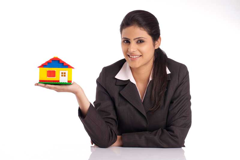 beautiful young businesswoman holding small house model against white