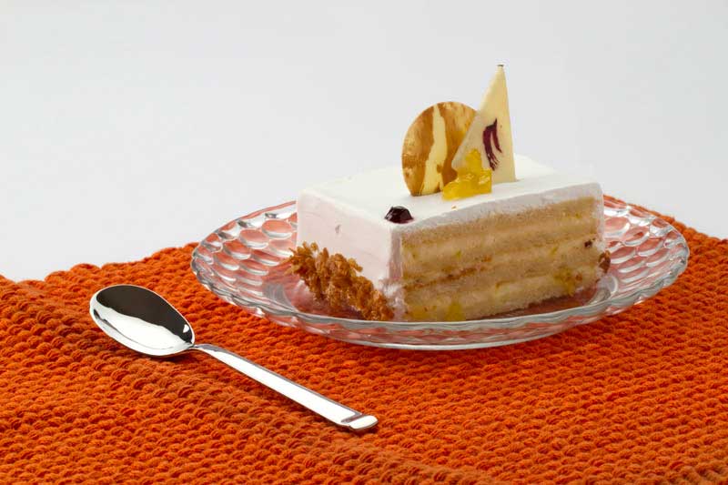 a slice of cream cake served on a dessert glass plate 