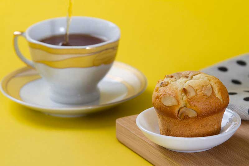 tea and muffin against yellow background