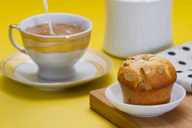 close up shot of muffin with tea served in the backgorund