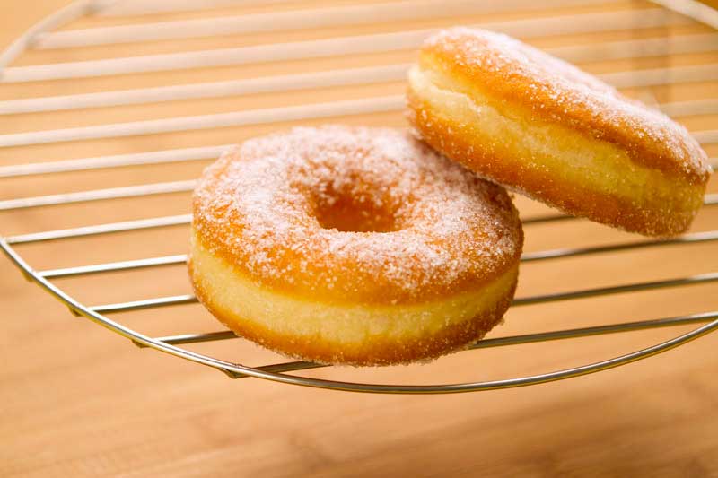 freshly baked donuts sprinkled with sugar on display  