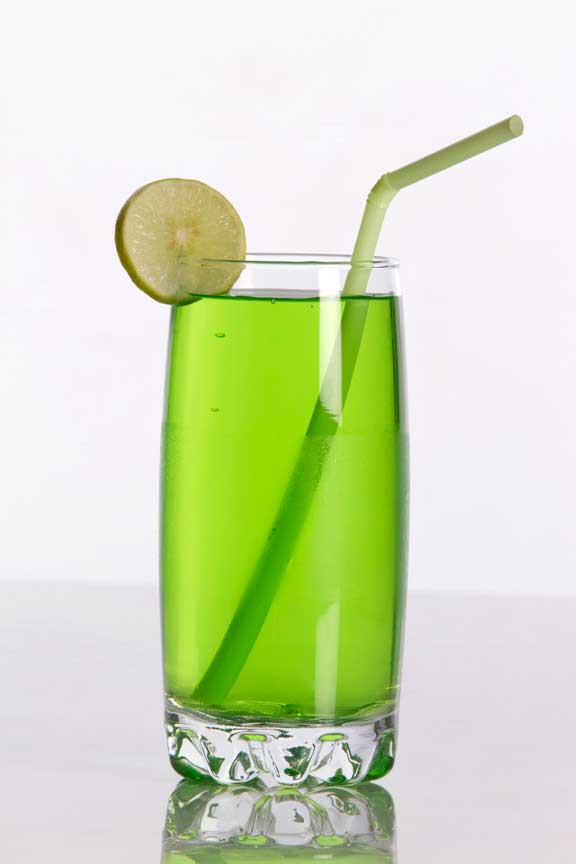green coloured soda drink with straw and lemon
