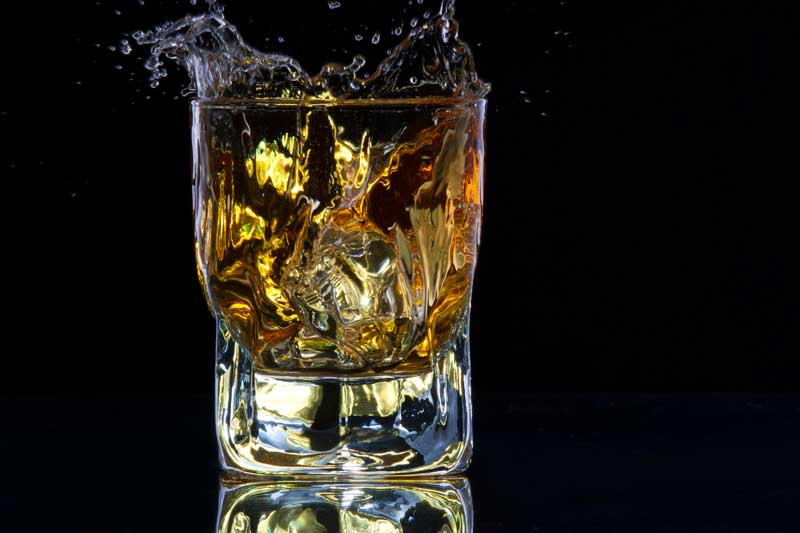whiskey splashing from a glass of whiskey