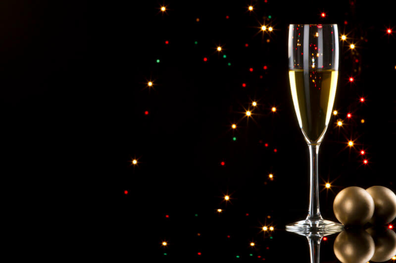 champagne glass with black background with decorative balls