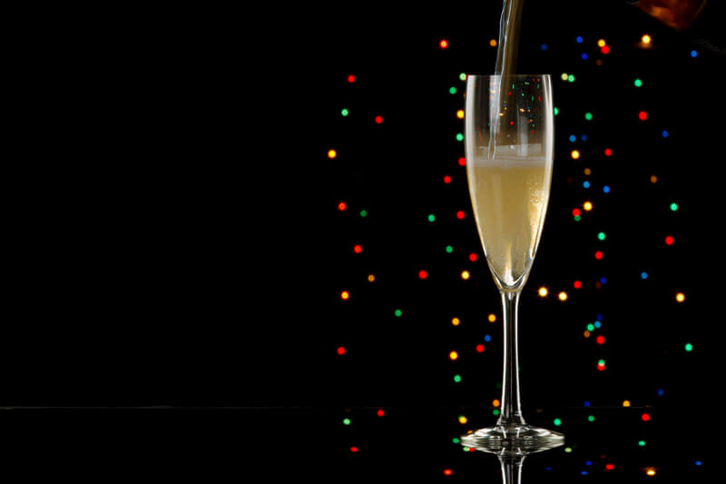 pouring champagne into glass with black background