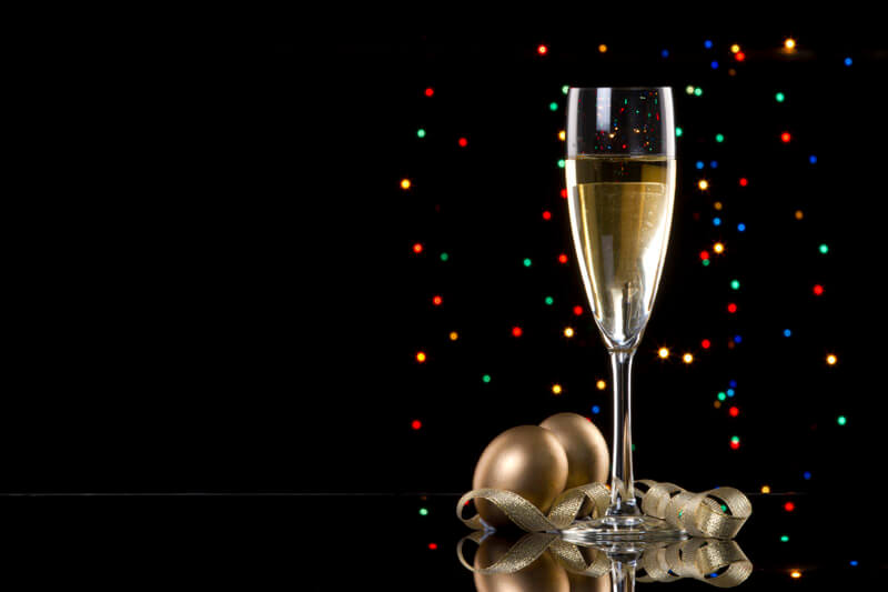 champagne glass with black background and decorative balls
