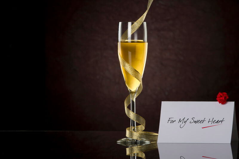 champagne glass with black background and note