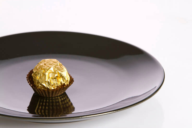 chocolate nut placed on a black plate against white background
