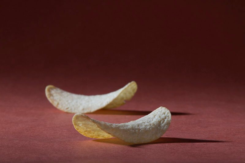 two potato chips against a red background