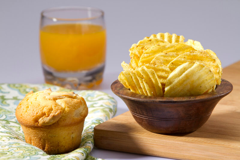 muffin,chips and a glass of juice on the table