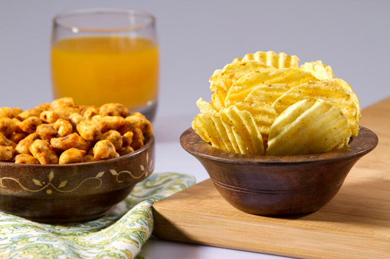 chips and peanuts with a glass of juice