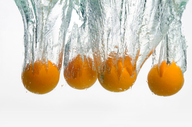 fresh oranges immersed into water