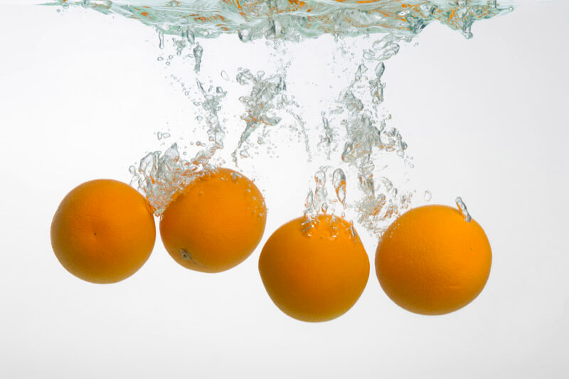 fresh oranges in water creating water art
