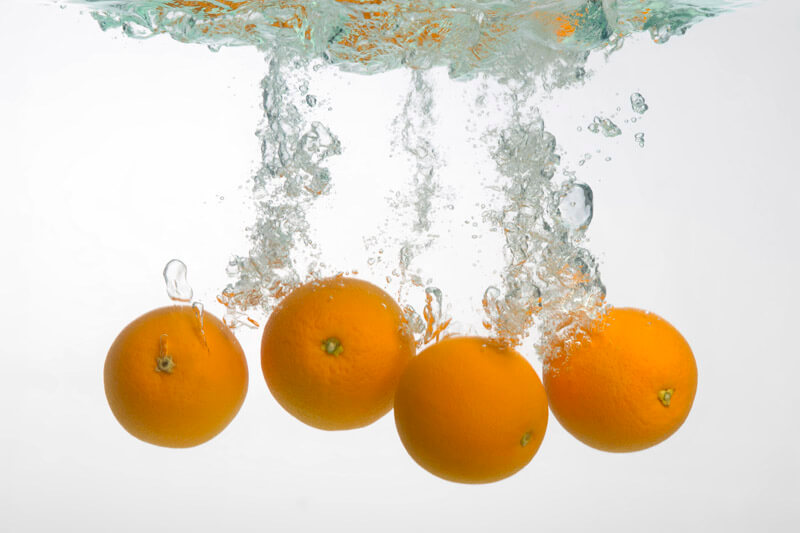 oranges splashed in a water tank
