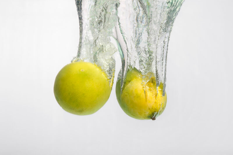 yellow coloured fruits falling into the water