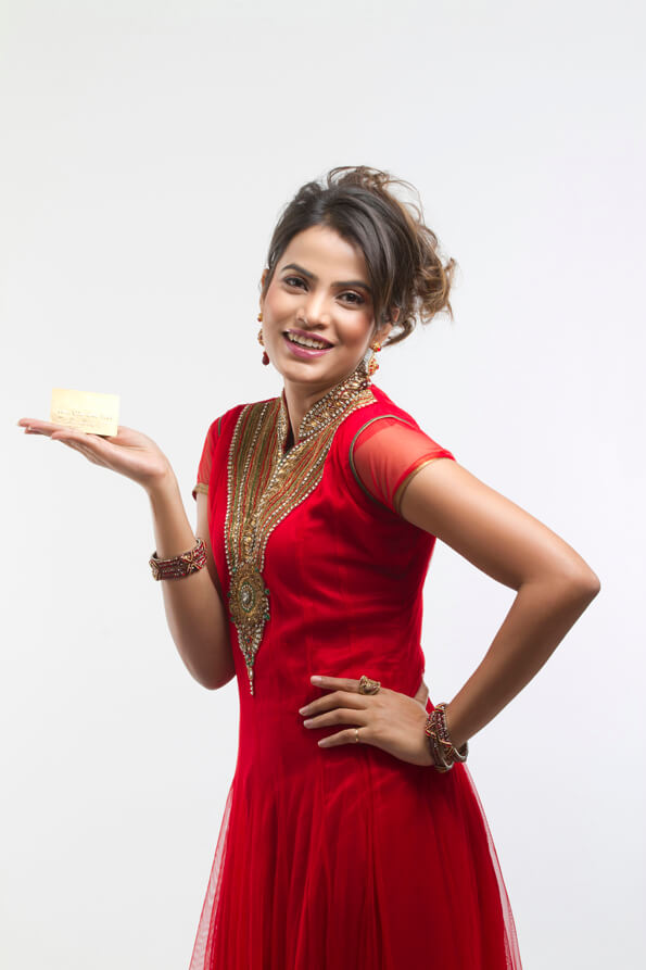 indian girl in red designer suit posing with a credit card