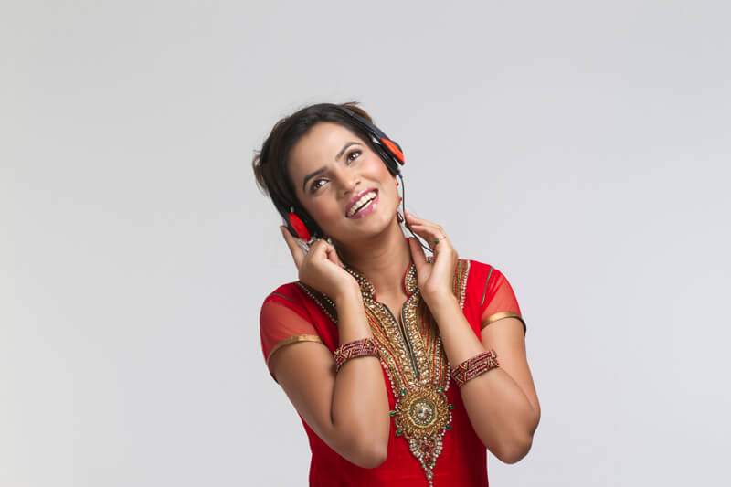 young girl in indian wear with headphones