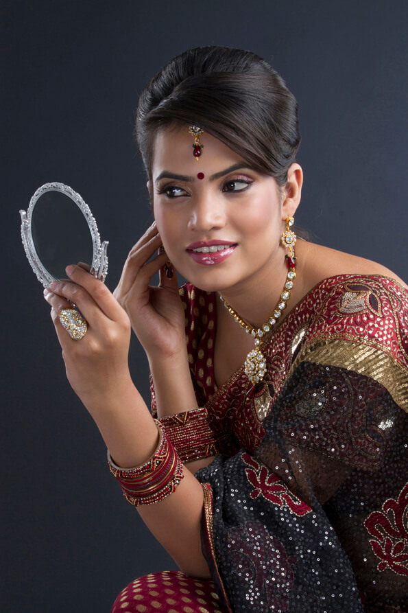 woman in traditional wear looking in the mirror