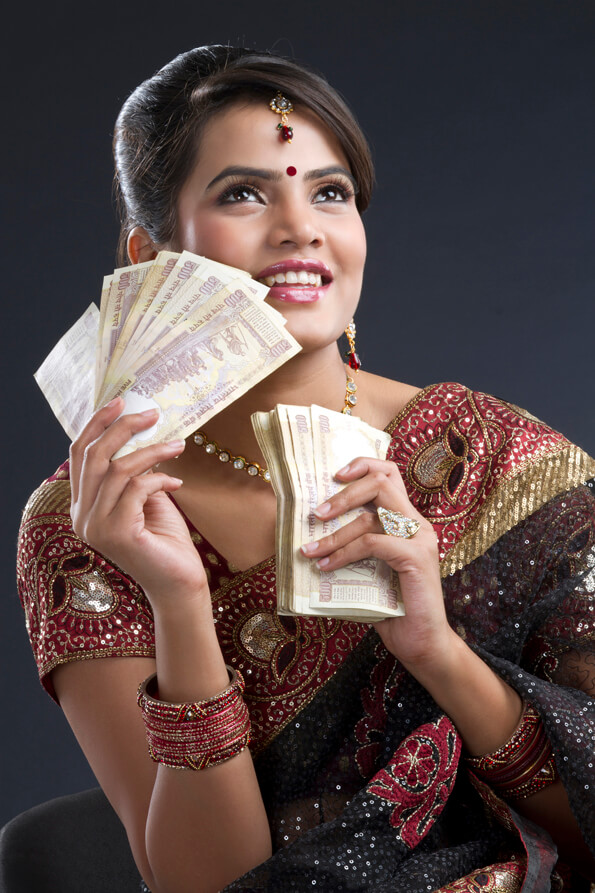 happy indian woman in saree holding indian currency notes