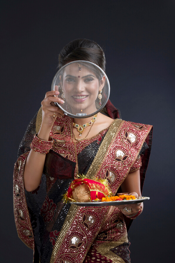 Indian woman looking through the strainer on karva chauth