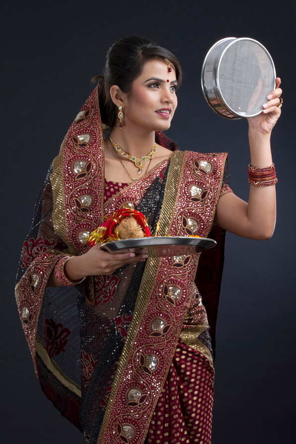Indian woman looking at the strainer on karva chauth