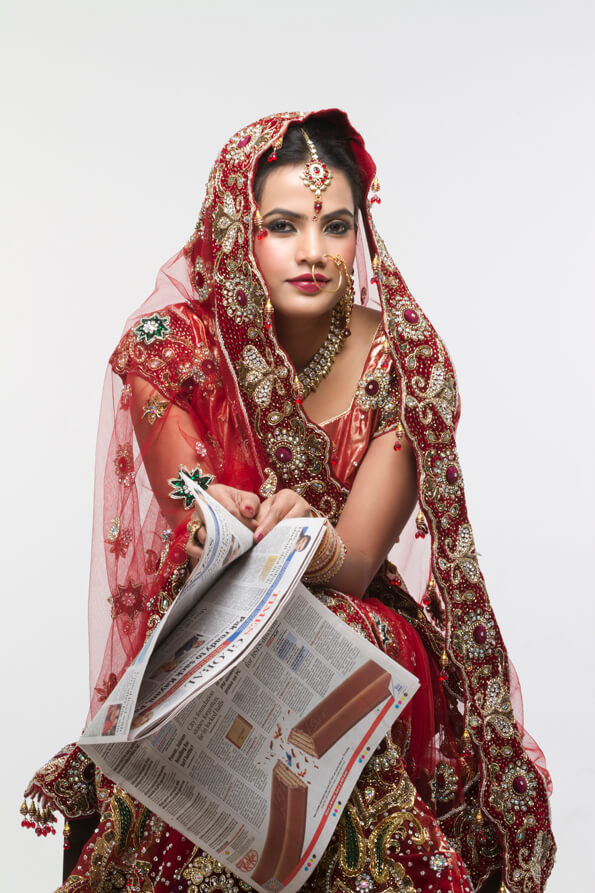indian bride posing with a newspaper 