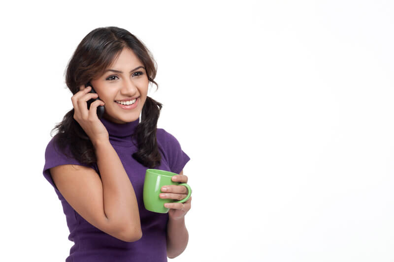 portrait of a young female holding coffee mug and cell phone