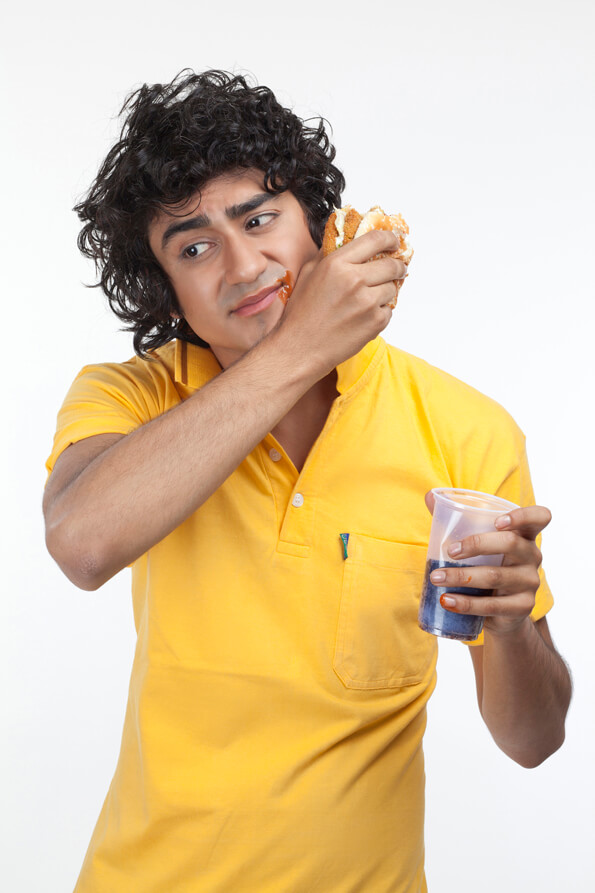 young male eating burger with a soft drink
