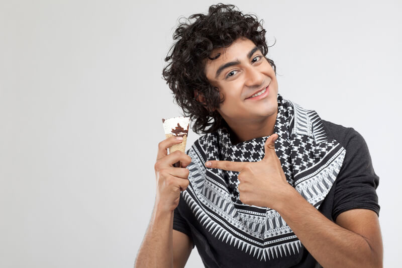 cheerful young male eating an ice cream