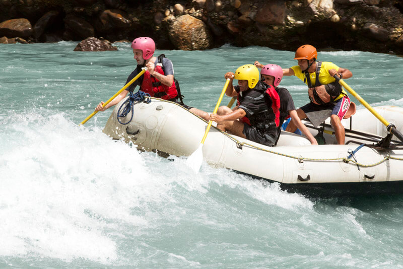 a group of men rafting in rishikesh
