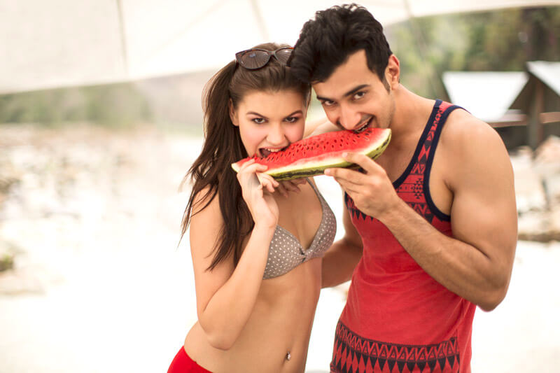  young boy and girl having a watermelon at the beach