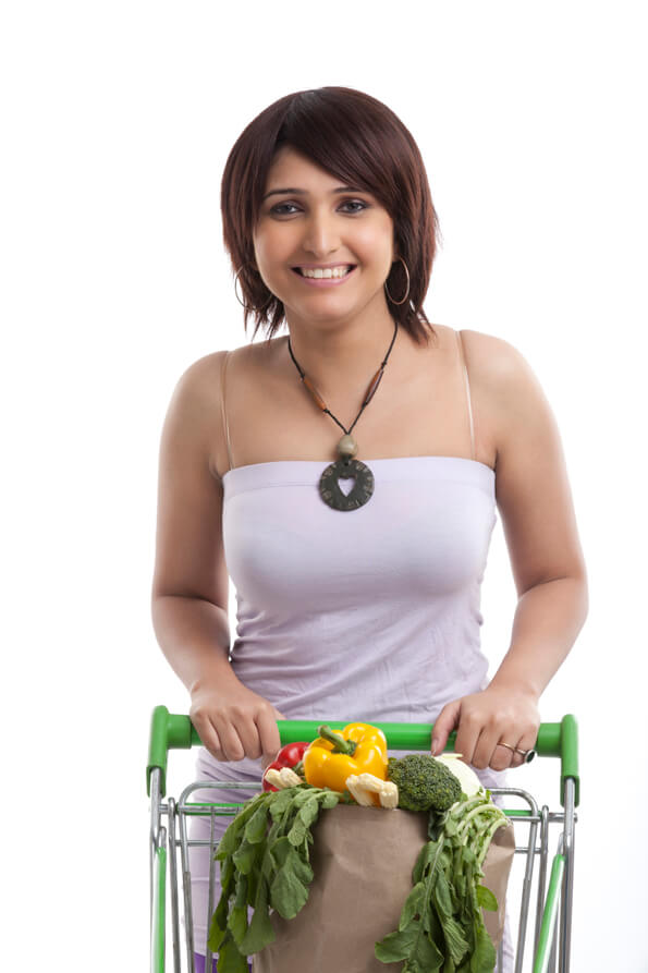 woman posing with vegetables and trolley