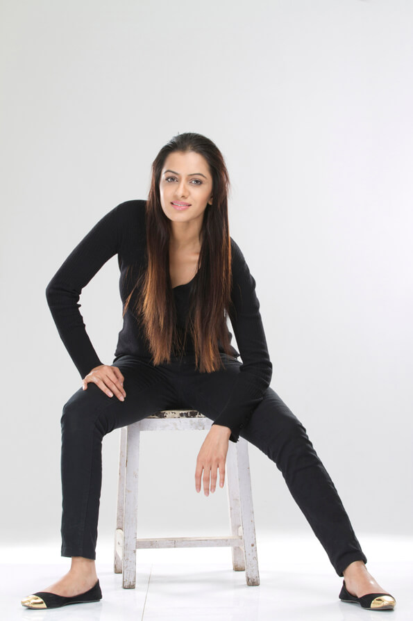 portrait of a stylish girl sitting on a stool against white background