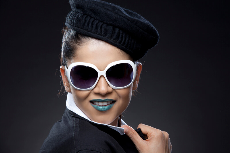 young girl posing with green lipstick and sunglasses