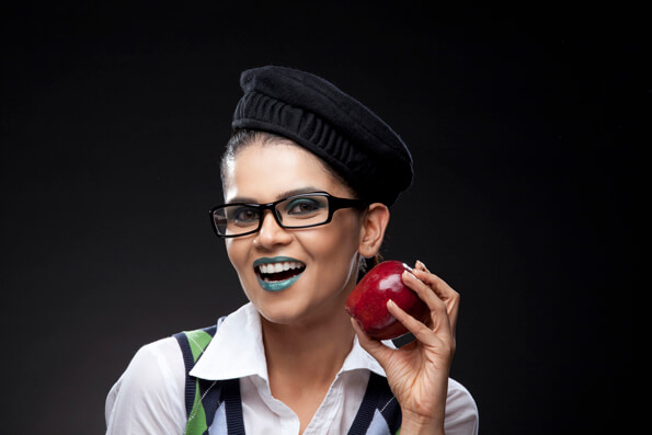 girl in a trendy make-up holding a red apple