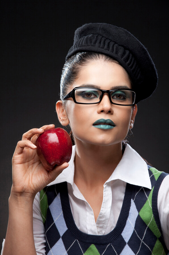 fashion model wearing glasses holding a red apple