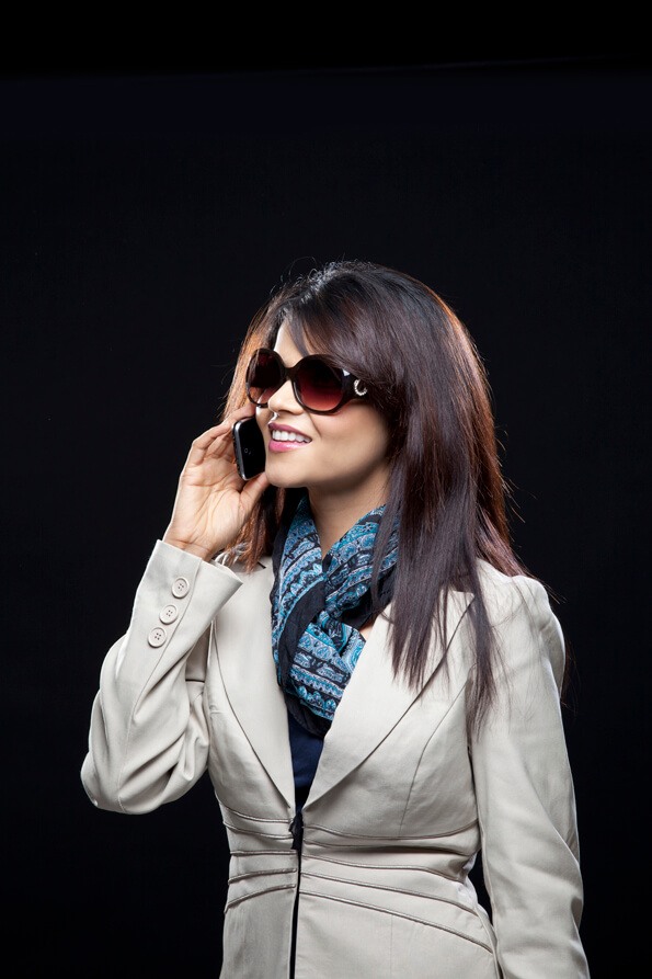 corporate girl with side pose smiling on the cell phone
