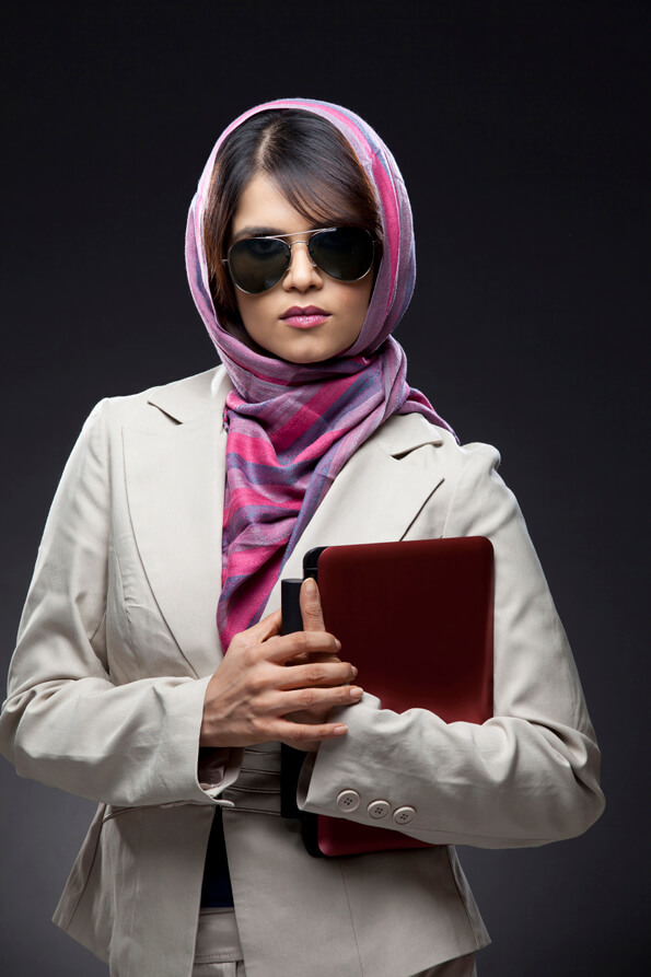 woman with aviator sunglasses carrying a laptop