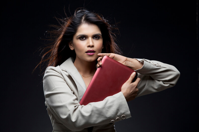 businesswoman holding a laptop close to her chest
