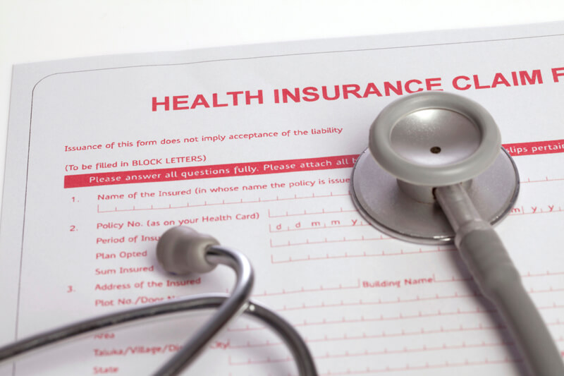 health insurance claim form lying on table with stethoscope