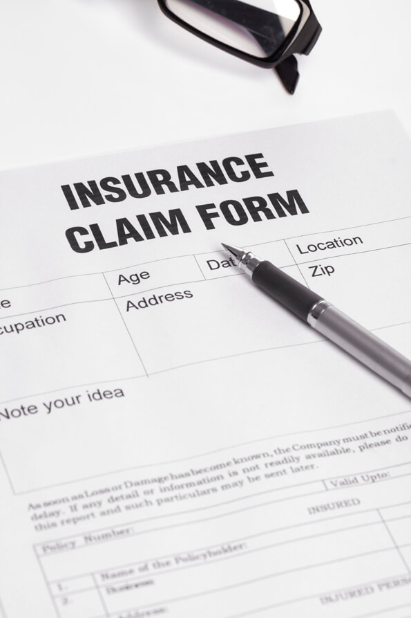 insurance claim application form with a pen on table 
