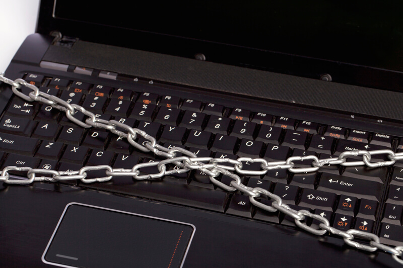 data protection concept with chained laptop