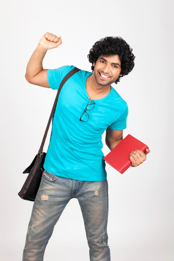 college boy holding book while posing for the camera