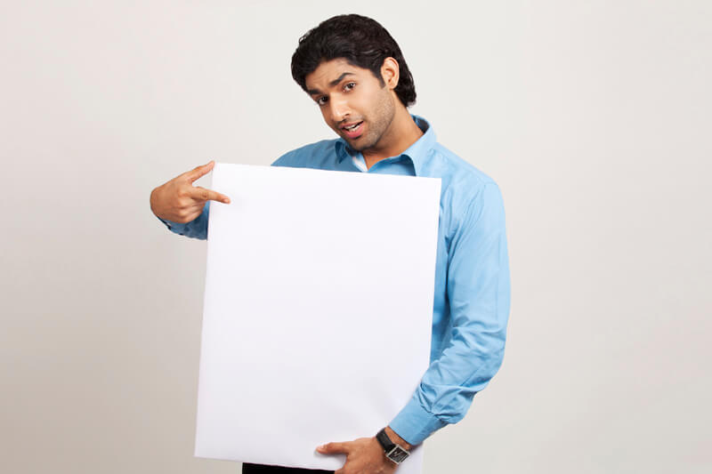 man pointing at placard while posing for the camera 