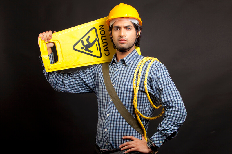 man dressed as engineer carrying caution board 