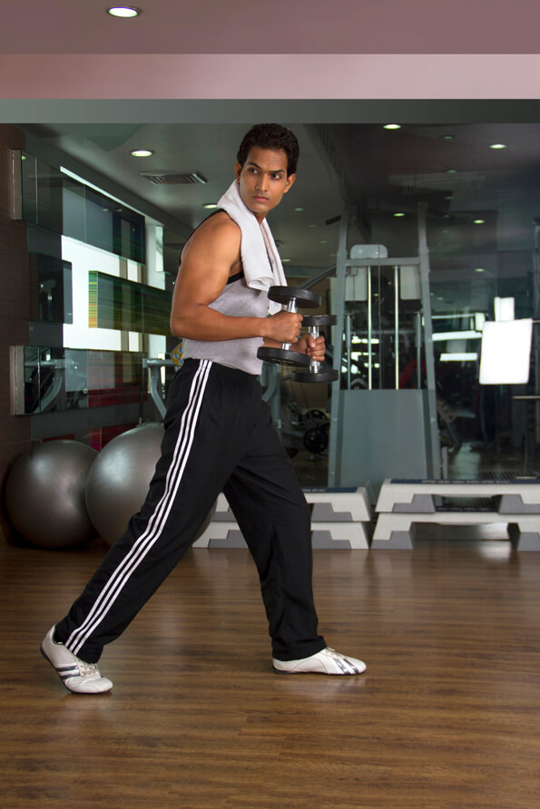 healthy man posing with dumbbells at the gym